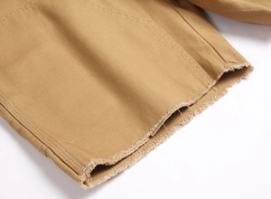 Détail du short en sergé kaki avec ourlet brut élégant et texture de tissu haut de gamme