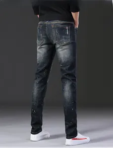 Vue arrière d'un jean slim délavé foncé avec détails usés et éclaboussures de peinture