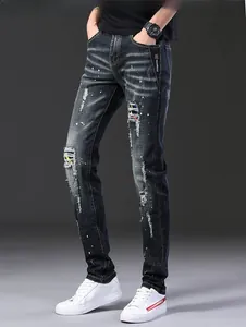 Détail de la texture denim déchiré avec des éclaboussures de peinture et une finition délavée