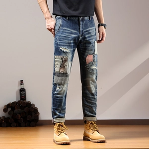 Mens vintage patchwork distressed denim jeans with red stripe patches and ripped details