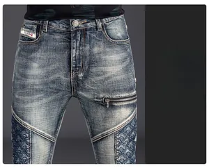 Detail showing the denim patchwork stitching and metal zipper accent on slim fit jeans