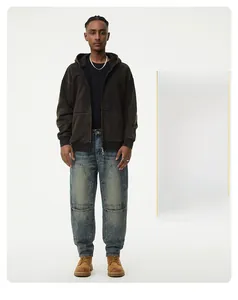Detail of loose-fit washed blue jeans with knee patches and retro high-street cargo design