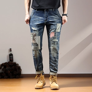 Men's retro distressed jeans with heavy embroidery patches and ripped denim details