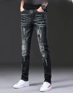 Détail macro du jean slim pour hommes avec déchirures, patchs et projections de peinture