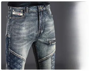 Close-up of vintage washed denim jeans with ethnic embroidery and zipper pocket detail