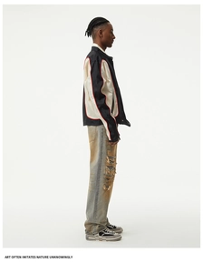 Close-up of baggy distressed denim jeans with frayed knee rips and washed finish detail