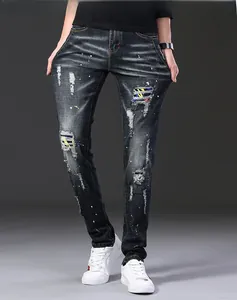 Détails du jean slim usé avec des taches de peinture et des écussons colorés