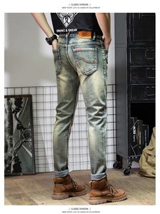 Detail view of vintage light blue washed denim jeans with premium leather waist patch