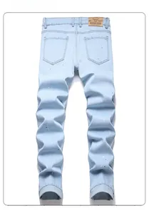 Rear view of light blue slim fit jeans with paint splatter details and leather back patch
