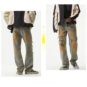 Detail of distressed vintage blue jeans with ripped knees and striped fabric lining