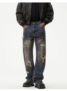 Nahaufnahme der Retro-Jeans mit manuellen Rissen und Vintage-Schlammflecken-Effekt