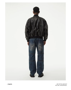 Rear view of vintage loose straight denim jeans with knee stitching and distressed details