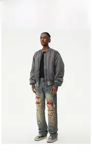Detail of blue distressed jeans with red plaid flannel patches and ripped knee design