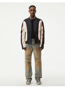 Detail of distressed light blue jeans featuring large knee rips with striped inner lining