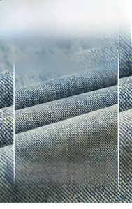 Gros plan détaillé du tissu denim bleu montrant le tissage sergé et la texture délavée