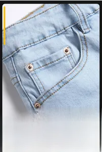 Close-up of slanted front pocket on light blue denim jeans with metal rivet details