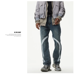 Détail de jean denim vintage avec traits de peinture blanche et éclaboussures rouges