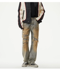 Detail of distressed vintage blue denim jeans with ripped holes and striped inner fabric