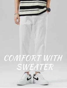 Dettaglio dei pantaloni bianchi a gamba dritta con risvolto per un look minimalista e pulito
