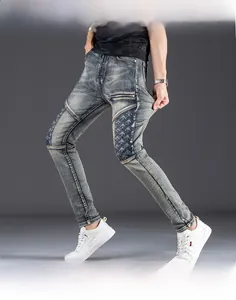 Detail of slim fit men's distressed jeans with blue patchwork and zip pocket features