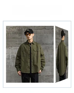 Détail d'une chemise de travail en coton vert militaire avec deux poches poitrine et coupe ample