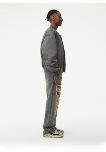 Side view of a grey bomber jacket with ribbed collar paired with ripped denim jeans