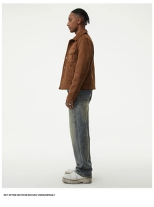 Detail view of retro brown suede jacket with chest pockets and washed straight jeans