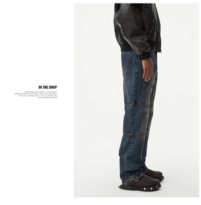 Close-up of deep blue vintage patchwork denim jeans with straight-leg cut and seam details