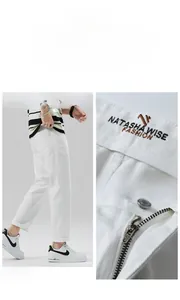 Dettaglio della cerniera YKK e ricamo del brand sui pantaloni dritti bianchi