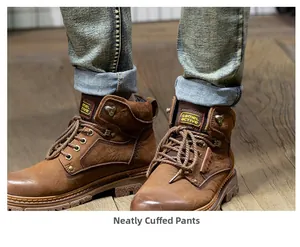 Close-up of premium brown leather boots with vintage stitching and washed gray denim jeans