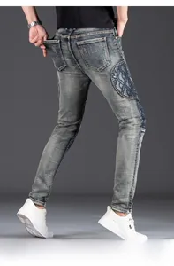 Detailed back view of slim fit blue jeans with patchwork design and vintage wash texture