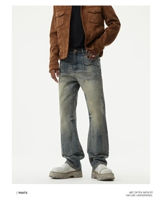 Close-up of vintage wash jeans featuring double-layer knee patches and contrast stitching