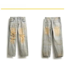 Flat lay of distressed straight leg jeans with vintage wash and ripped hole details