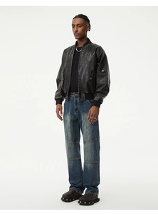 Vue complète d'un blouson aviateur noir en similicuir et d'un pantalon large en jean bleu