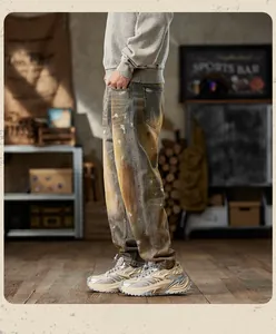 Side view of men's loose vintage jeans featuring distressed mud wash and paint splatters