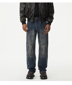 Detail of distressed vintage blue denim jeans with multi-panel patchwork and frayed textures