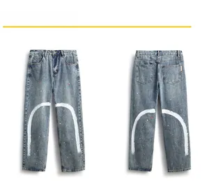 Détails du jean délavé bleu clair avec traits blancs et taches de peinture rouge