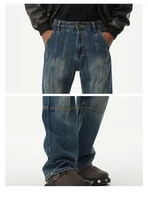 Détail du jean délavé bleu foncé avec plis à la taille et coutures sur pantalon large