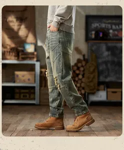 Detail of distressed vintage men's jeans featuring patchwork and heavy wash texture