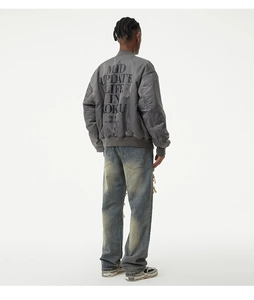 Back view of a men's vintage grey bomber jacket featuring artistic text and denim jeans