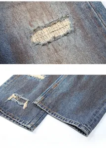 Detail von blauen Vintage-Jeans mit Rissen am Knie und ethnischem Patchwork-Muster