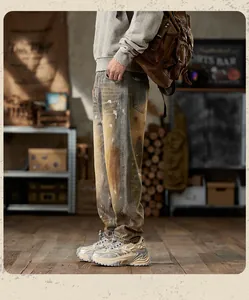 Detail showing vintage wash straight-leg jeans with artistic paint splatter and retro style