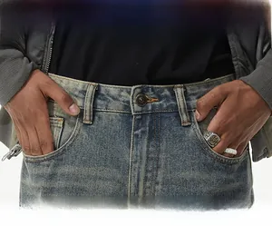 Macro view of vintage washed blue denim jeans featuring metal button and distressed texture