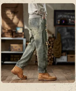 Detail of vintage gray ripped jeans showing distressed texture and patchwork details on legs