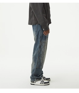 Détail d'un jean en denim bleu rétro à jambe droite avec un patchwork matelassé sur le côté