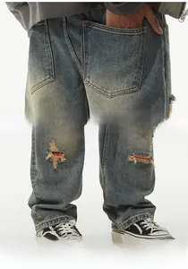 Detail of vintage washed blue jeans with ripped knees and red-white-blue ribbon patches