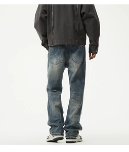 Vue détaillée du jean droit rétro bleu et veste grise avec zips au dos du vêtement