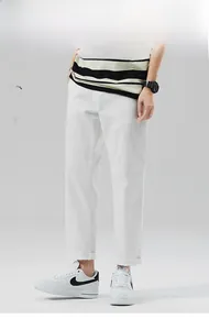 Dettaglio dei pantaloni bianchi uomo a gamba dritta con orlo semplice stile high-street