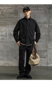 Détail d'une chemise de travail en coton noir lourd avec tissu robuste et poches poitrine