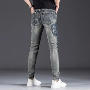 Men's slim fit patch denim jeans in deep blue wash with elegant embroidery on the back